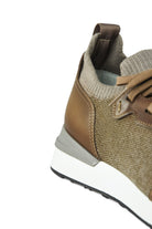 Side close-up of tan knit and leather trainer with elastic collar and white midsole