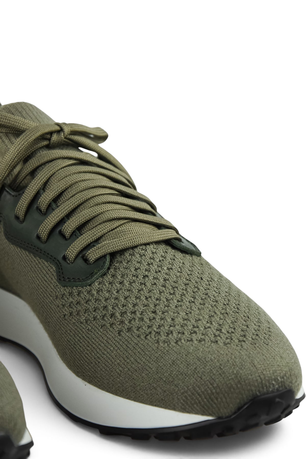 Close-up of khaki knit lace-up sneaker with textured toe and dark lace eyelets
