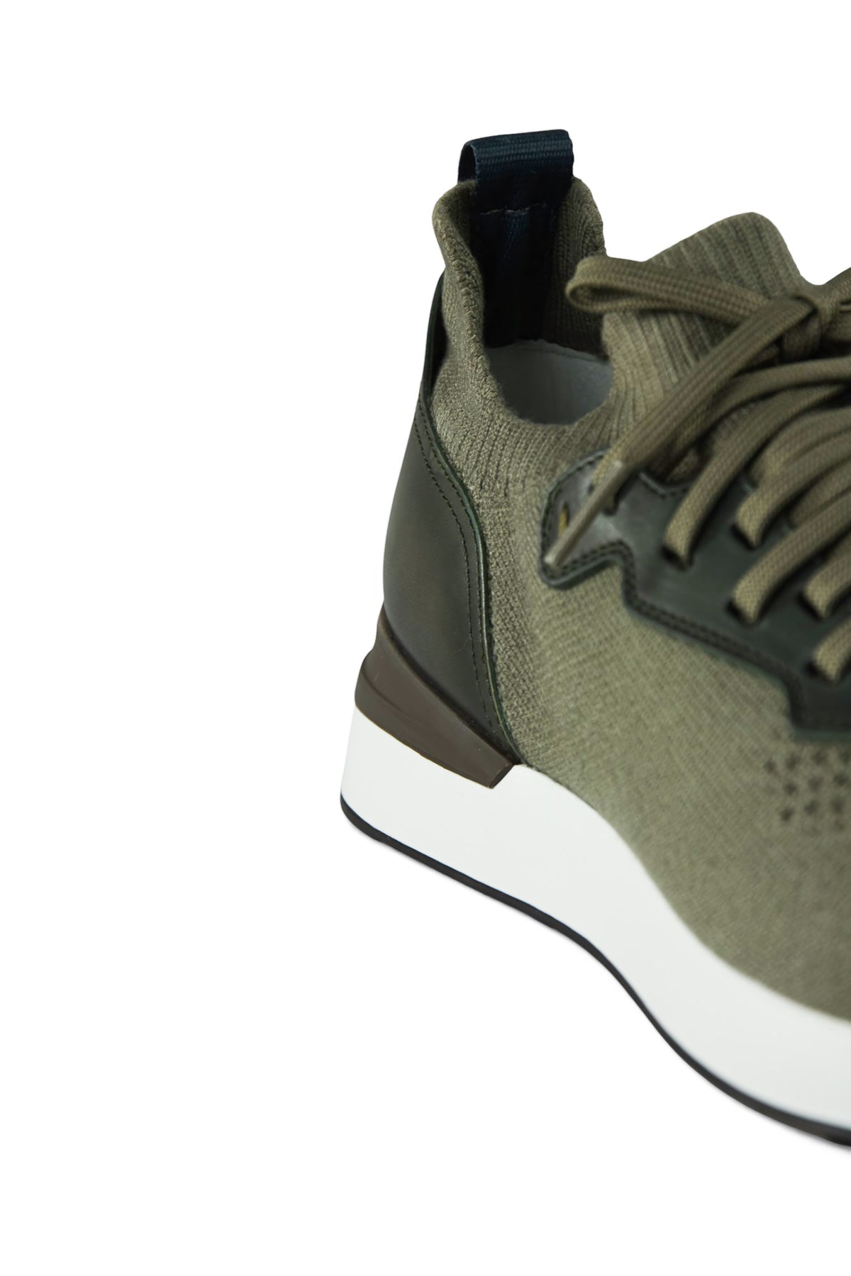 Side view of khaki sneakers showing knit upper, leather trim, and white sole