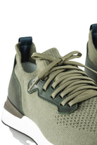 Khaki lace-up sneaker close-up with knit texture, leather quarter panel, and dark lining