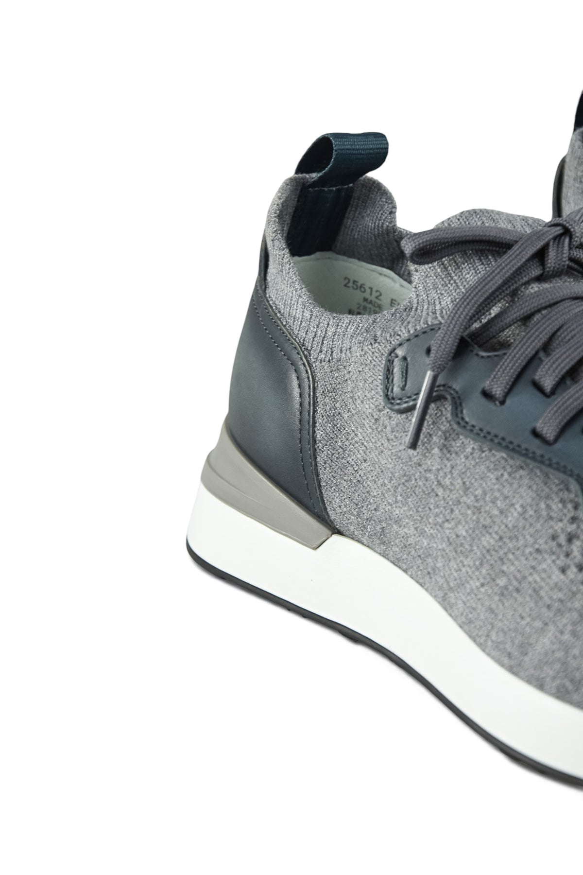 Side view of grey knit trainer with leather panel and lace-up pull tab