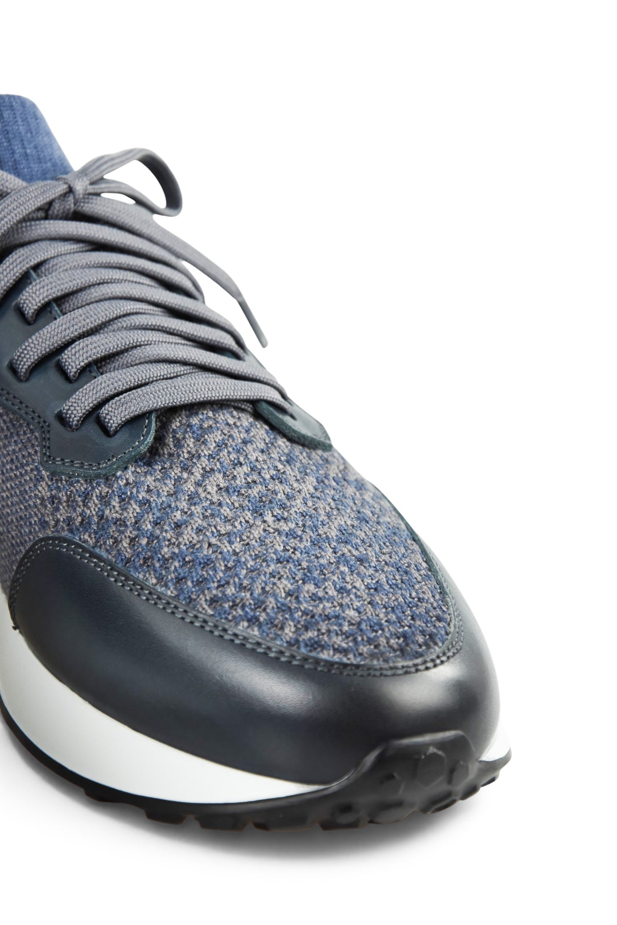 Close-up of grey speckled knit toe with lace-up hardware and dark leather panel
