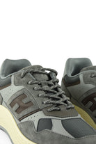 Close-up of grey lace-up trainer showing H logo, laces, and padded tongue