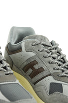 Close-up of grey sneaker upper with textured trim, lace eyelets, and thick light midsole