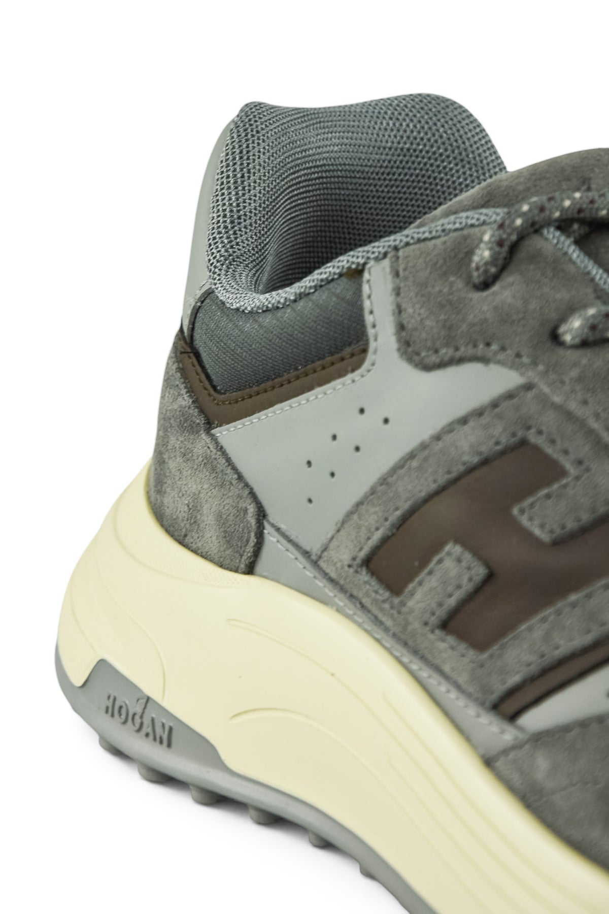 Side close-up of grey trainer with mesh collar, suede overlay, and light yellow midsole