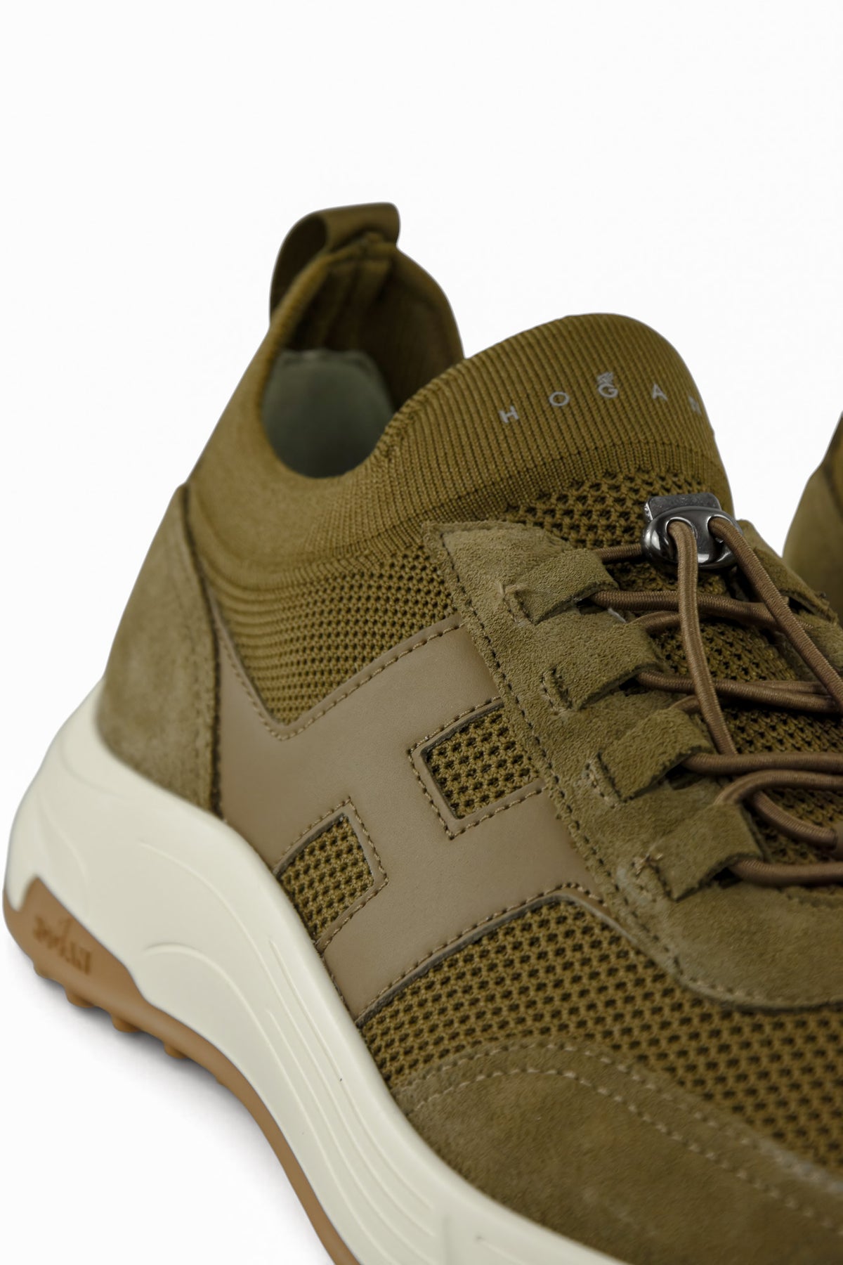 Khaki trainer side close-up with suede overlays, mesh panel, and white midsole