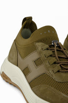 Khaki trainer side close-up with suede overlays, mesh panel, and white midsole