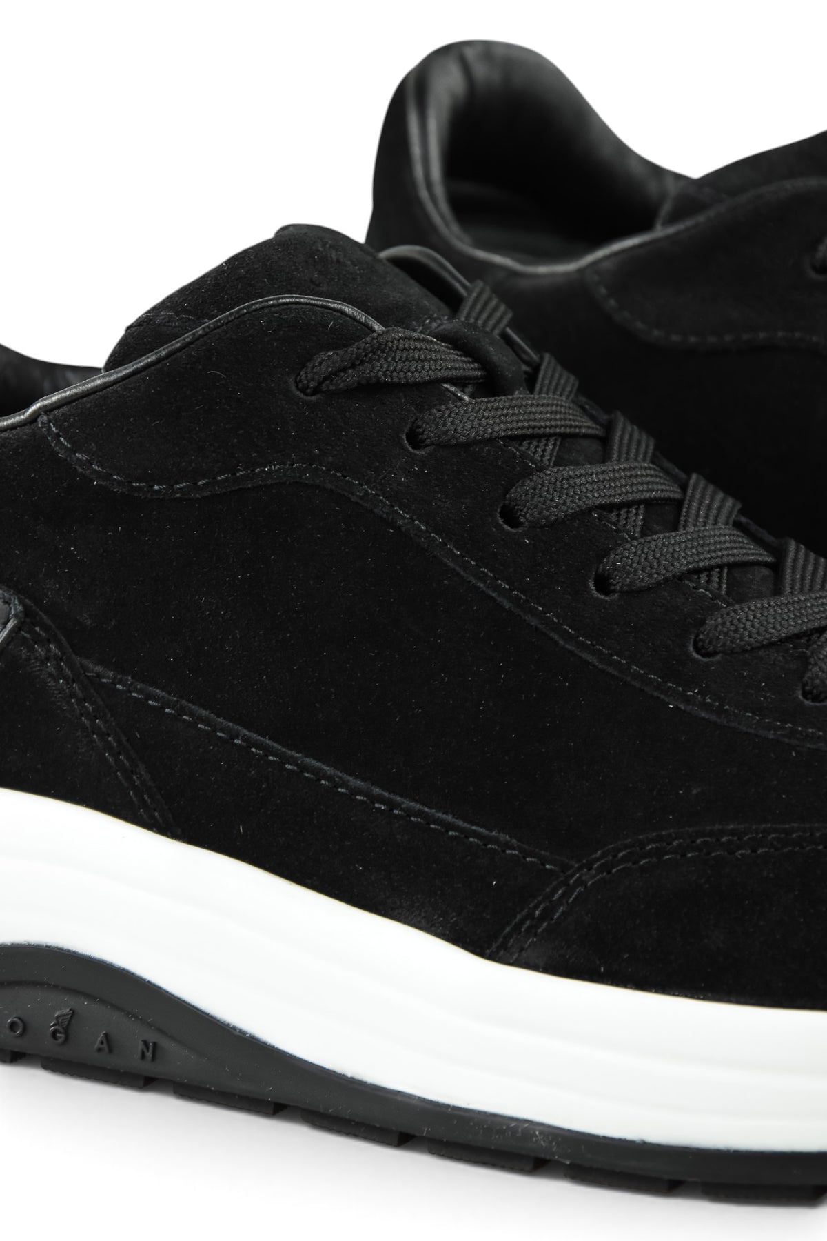 Close-up of black suede lace-up toe with contrast stitching and white midsole