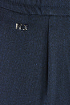 Navy textured jersey pants with metal logo detail on waistband