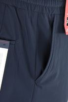 Dark navy technical stretch pants with side seam and stitched pocket detail.
