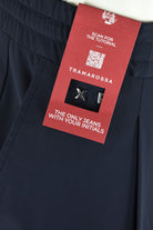 Dark navy technical stretch pants with red brand tag on pocket area.