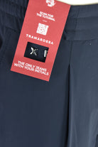 Dark navy technical stretch pants with red brand tag on upper pocket area.