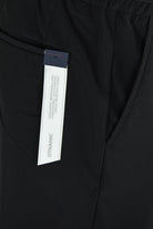 Black technical stretch pants with interior fabric label near waistband
