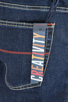 Dark blue denim jeans pocket with stitched edge and multicolor brand label lining.