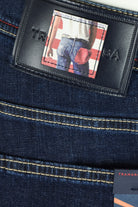 Black leather-look jeans label patch with Tramarossa logo and dark blue stitching.