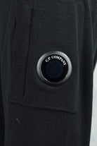 C.P. Company lens badge on dark merino wool half-zip jumper pocket