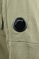 Olive green sweatshirt with round C.P. Company lens badge on chest