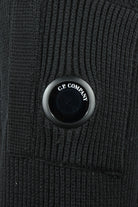 C.P. COMPANY branded metal button on black rib-knit fabric panel