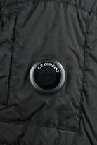 Close-up of black jacket front with C.P. Company logo button detail