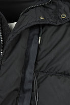 Close-up of black jacket front zipper with metal pull and side pocket seam