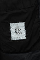 Inside label of black padded jacket showing C.P. Company logo patch
