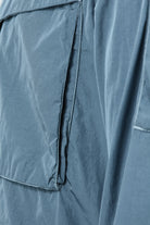 Blue overshirt front placket with black zipper and stitched seam details