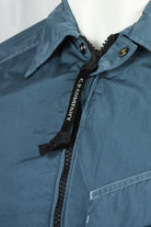 Blue overshirt zipper area with black tape and stand collar