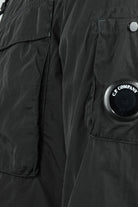 Black overshirt close-up of flap pocket and circular logo badge