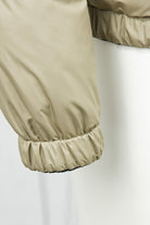Beige quilted jacket sleeve with elastic cuff and stitched paneling