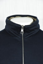 Dark blue jacket collar close-up with full-zip slider and interior beige lining