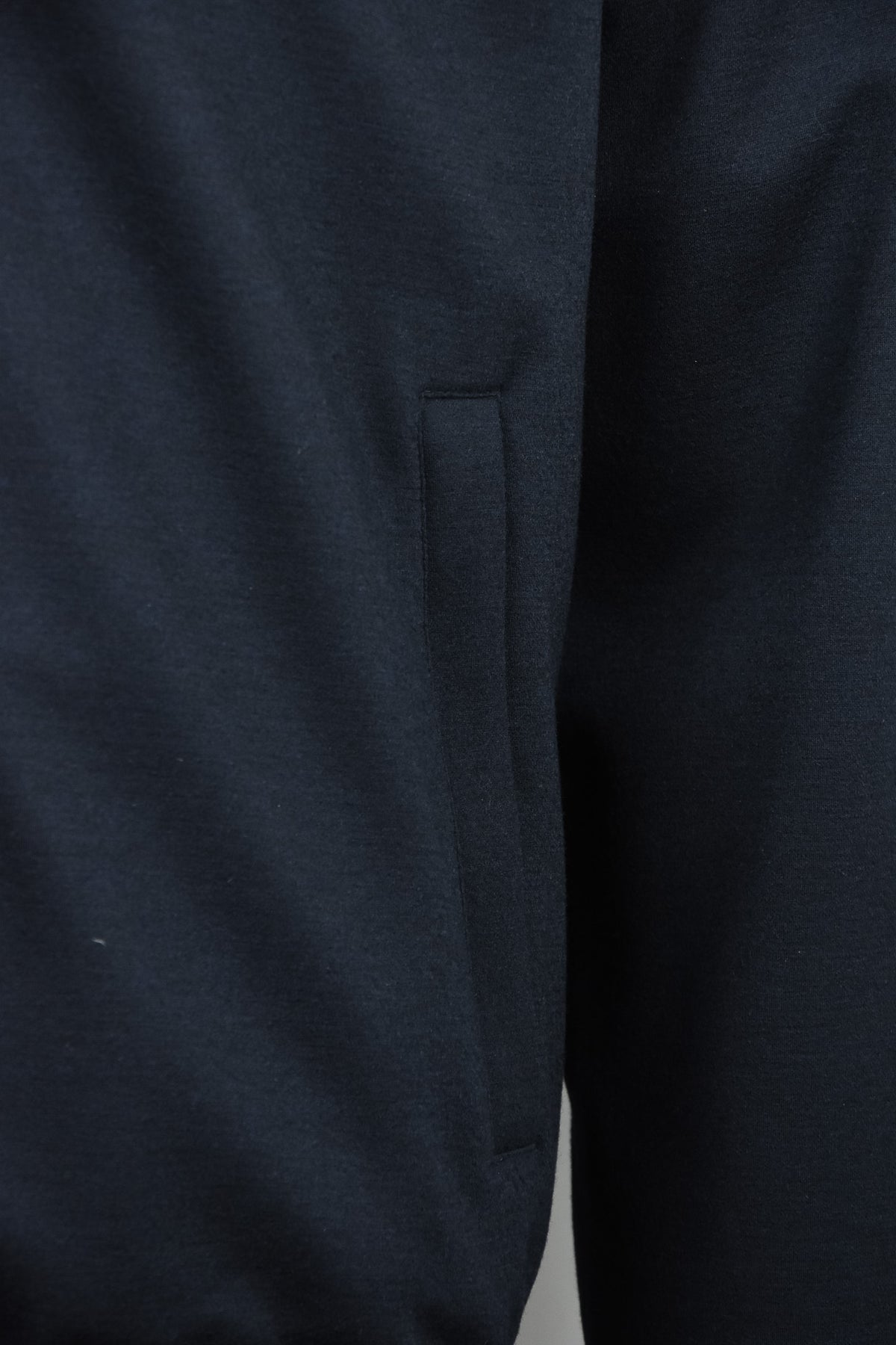Dark blue padded wool jacket with side pocket and tapered hem