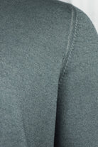 Petrol blue knit cardigan with textured shoulder seam and ribbed stand collar.
