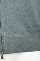 Petrol blue ribbed hem and metal zip on full-zip knit cardigan, close-up.