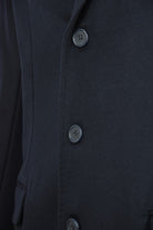 Overcoat front detail with three dark buttons on wool-cashmere fabric