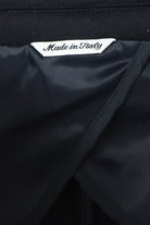 Overcoat interior label reading Made in Italy beside dark lining