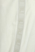White velour track pants with vertical FILA tape stripe along the side