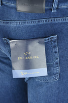 Close-up of mid-blue jeans with a Giza cotton label beside the back pocket