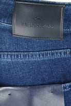 Close-up of the black Paul & Shark leather waistband badge on mid-blue denim