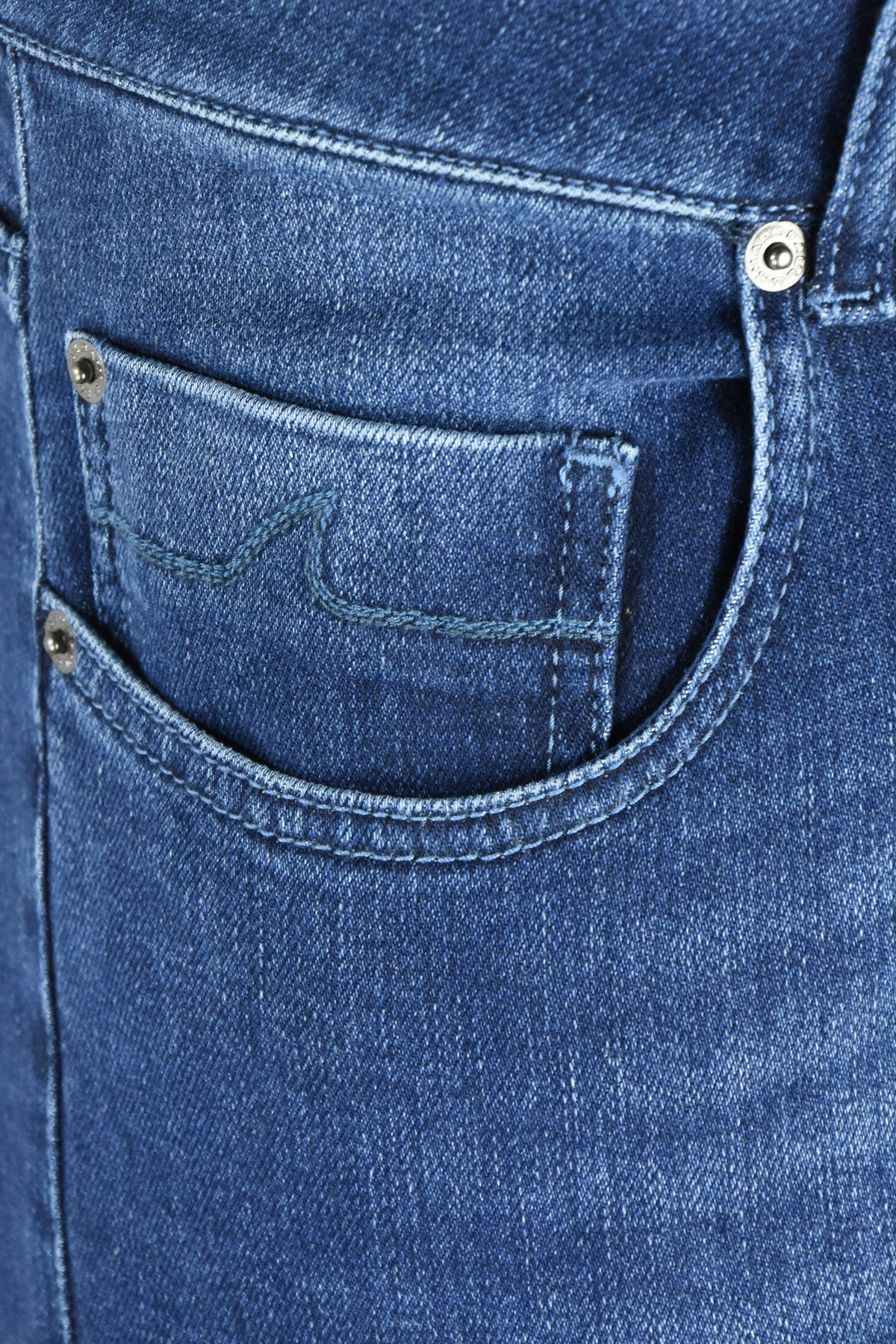 Close-up of the front pocket, coin pocket and rivets on mid-blue denim jeans