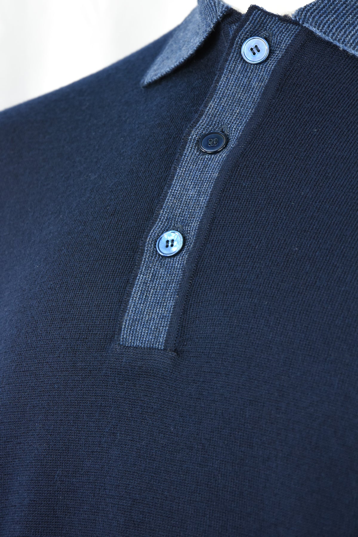 Navy wool polo detail with blue contrast placket and three buttons