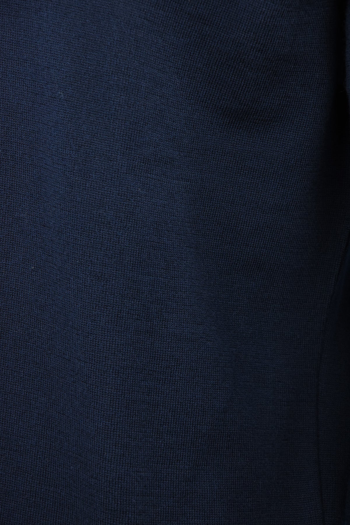 Close-up of the fine knit texture on a navy wool polo