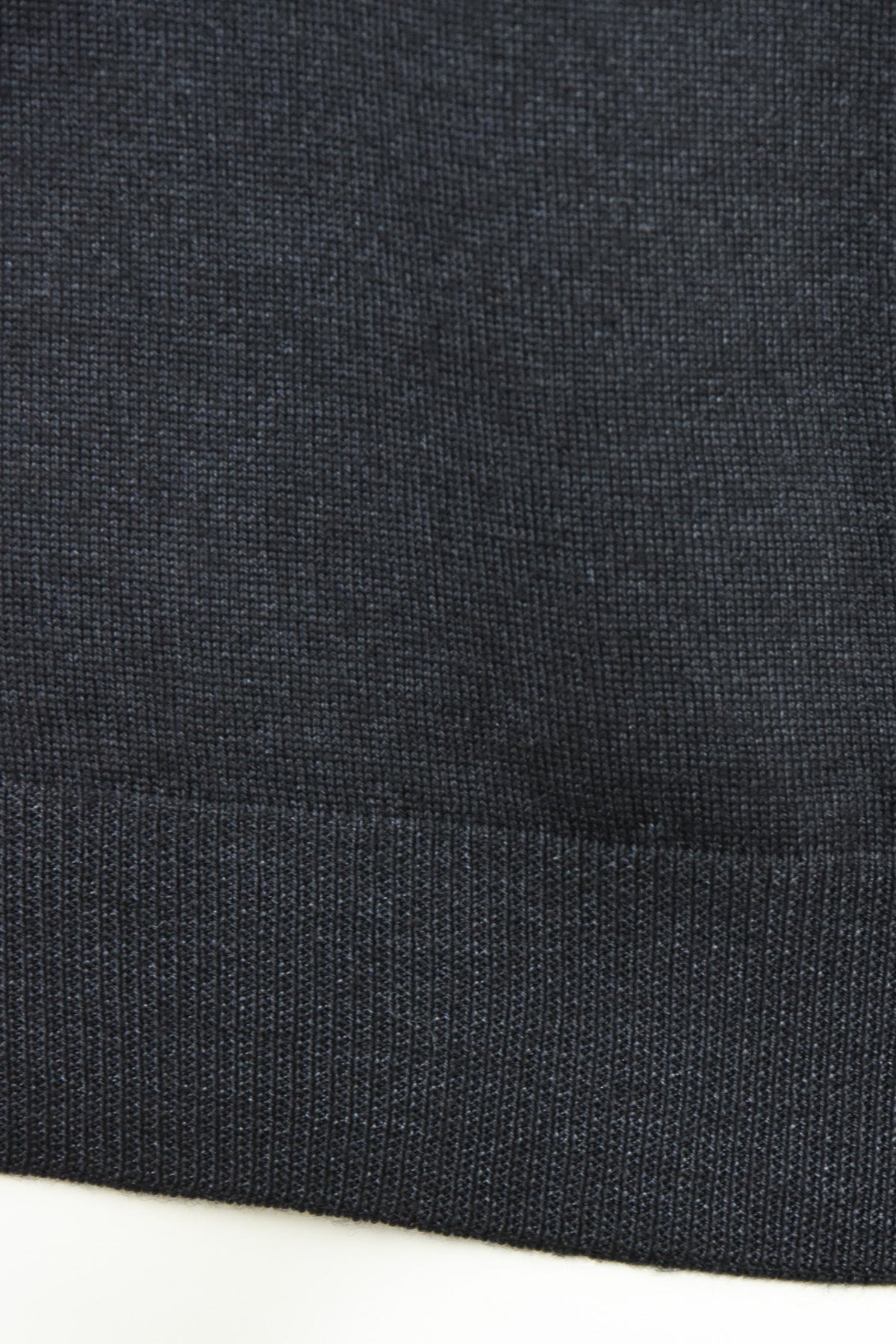 Close-up of the jumper's ribbed hem and knit texture