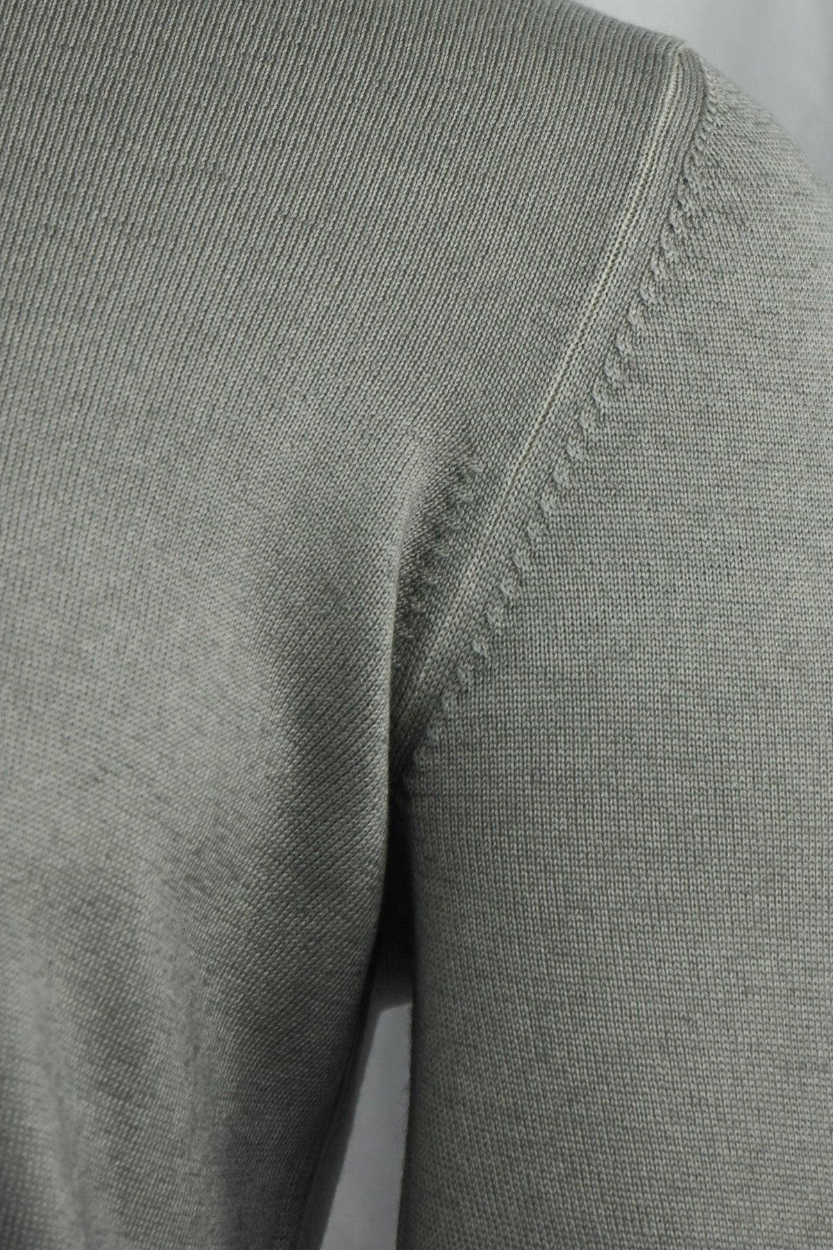 Grey-beige cardigan close-up showing the shoulder seam and knit texture