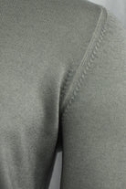 Grey-beige cardigan close-up showing the shoulder seam and knit texture