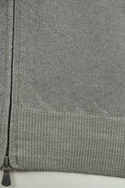 Cardigan close-up showing the ribbed hem and zipper base