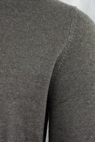 Close-up of the cardigan's gray knit fabric and shoulder seam