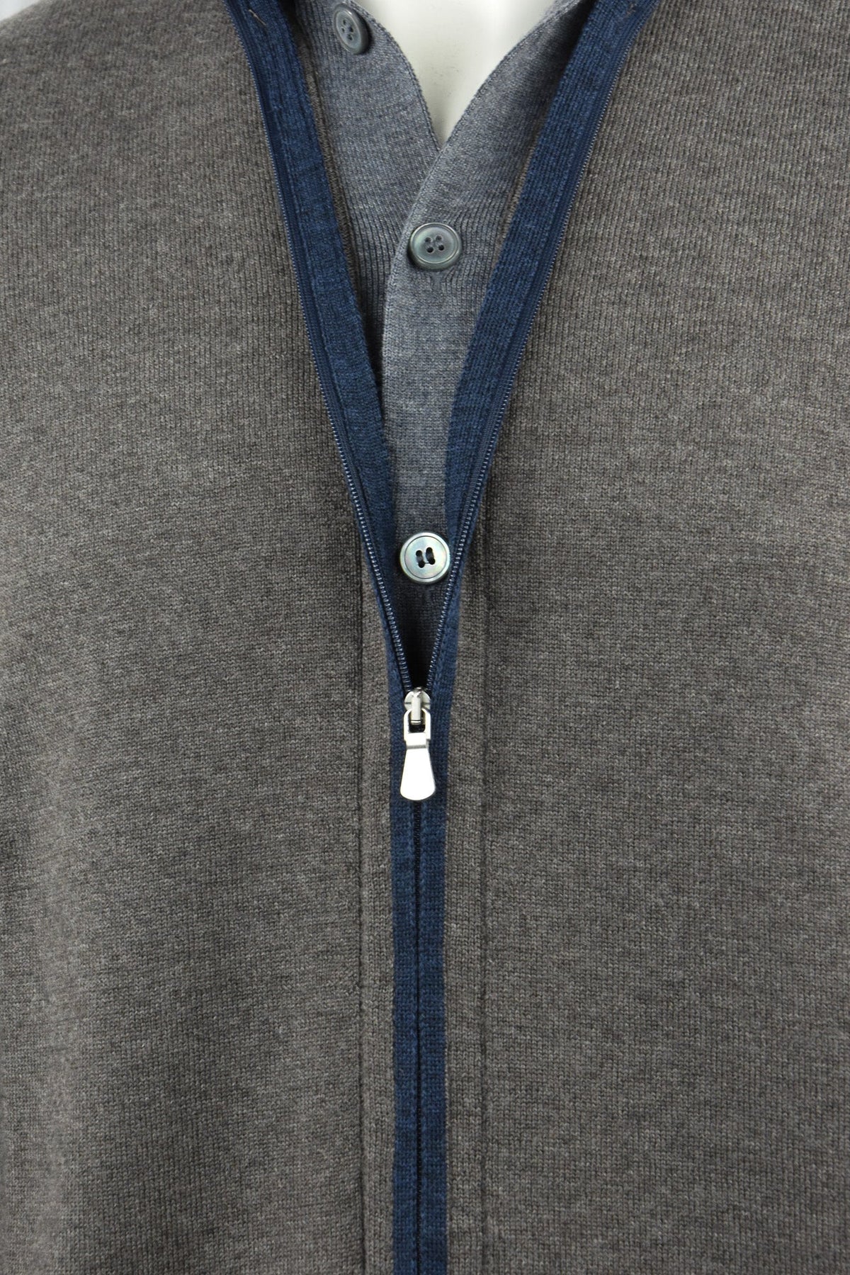 Cardigan front detail with blue zipper trim, zipper pull and buttons