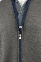 Cardigan front detail with blue zipper trim, zipper pull and buttons
