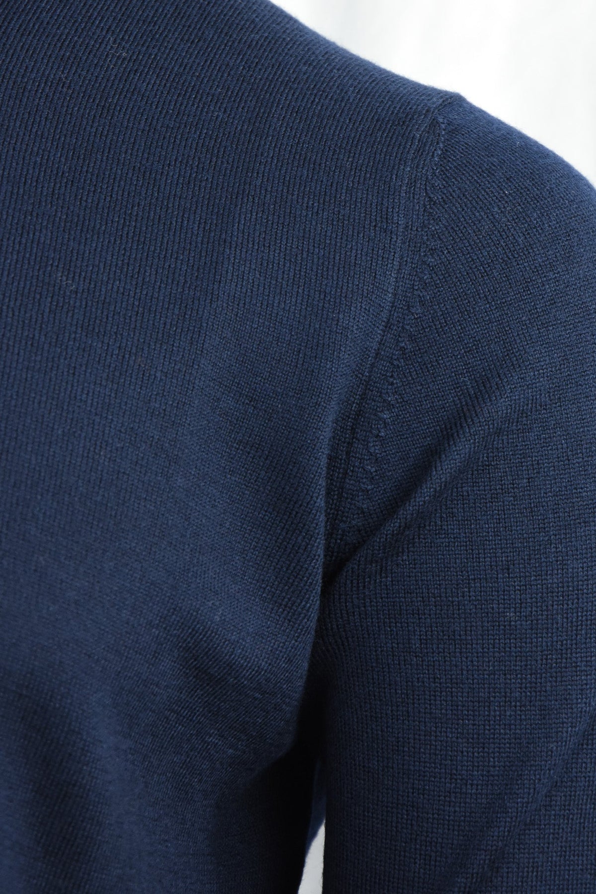Navy cardigan shoulder detail showing the knit texture and sleeve seam