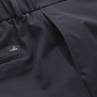 Dark navy tech travel shorts with stitched logo patch and pleated waistband